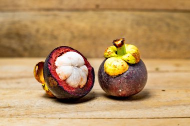 Ahşap arka planda izole edilmiş mangosteen meyvesi. Mangosteen çok yüksek seviyede antioksidan içeren bir meyve olarak bilinir. Sarsinya mangostana