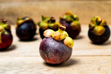 Ahşap arka planda izole edilmiş mangosteen meyvesi. Mangosteen çok yüksek seviyede antioksidan içeren bir meyve olarak bilinir. Sarsinya mangostana