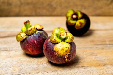 Ahşap arka planda izole edilmiş mangosteen meyvesi. Mangosteen çok yüksek seviyede antioksidan içeren bir meyve olarak bilinir. Sarsinya mangostana
