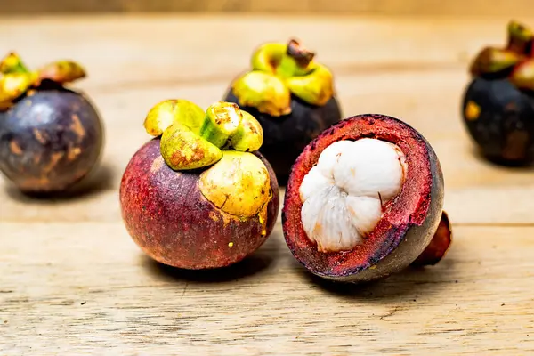 Ahşap arka planda izole edilmiş mangosteen meyvesi. Mangosteen çok yüksek seviyede antioksidan içeren bir meyve olarak bilinir. Sarsinya mangostana