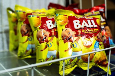 Endonezya - 21 Mayıs 2024: Bir mağaza rafında paketlenmiş atıştırmalıkların düzenlenmesi 