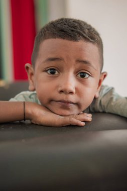 Kanepede bir çocuk oturuyor.