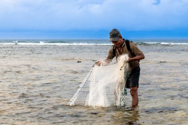 Endonezya - 3 Haziran 2024: Bir balıkçı ağını atıyor