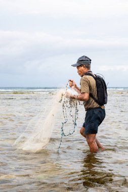 Endonezya - 3 Haziran 2024: Bir balıkçı ağını atıyor