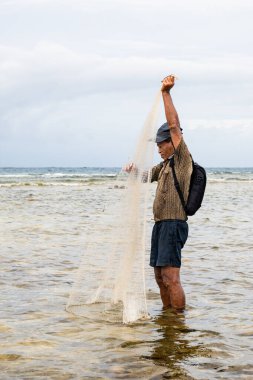 Endonezya - 3 Haziran 2024: Bir balıkçı ağını atıyor