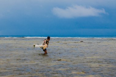Endonezya - 3 Haziran 2024: Bir balıkçı ağını atıyor