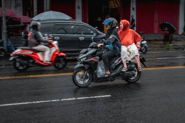 Ambon, Endonezya - 8 Haziran 2024: Endonezya 'da bir pazarın yakınındaki otoyolda motosikletler sürüyor