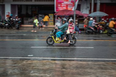 Ambon, Endonezya - 8 Haziran 2024: Endonezya 'da bir pazarın yakınındaki otoyolda motosikletler sürüyor