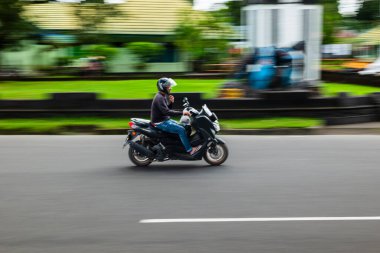 Ambon, Endonezya - 20 Haziran 2024: Otoyolda motosiklet sürmek