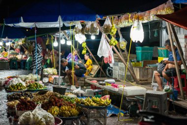 Ambon, Endonezya - 30 Haziran 2024: Geceleri geleneksel bir pazarda yol kenarında sebze ve meyve satmak