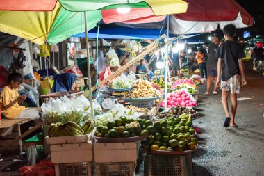 Ambon, Endonezya - 30 Haziran 2024: Geceleri geleneksel bir pazarda yol kenarında sebze ve meyve satmak