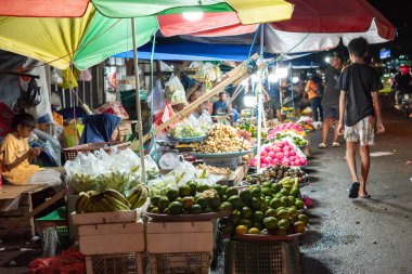 Ambon, Endonezya - 30 Haziran 2024: Geceleri geleneksel bir pazarda yol kenarında sebze ve meyve satmak