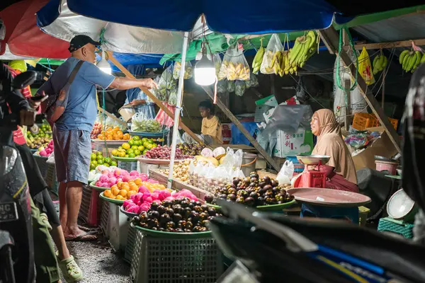 stock image Ambon, Indonesia - June 30, 2024: Selling vegetables and fruit on the roadside at a traditional market at night