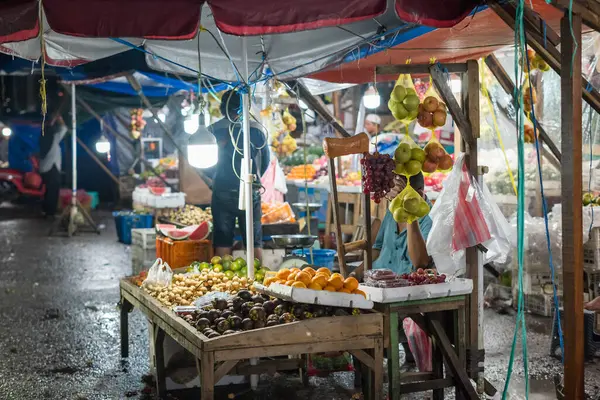 stock image Ambon, Indonesia - June 30, 2024: Selling vegetables and fruit on the roadside at a traditional market at night