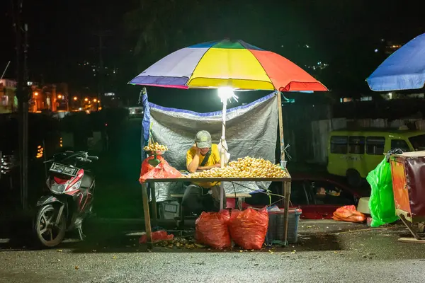 stock image Ambon, Indonesia - June 30, 2024: Selling vegetables and fruit on the roadside at a traditional market at night