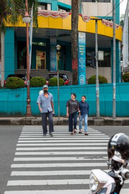 Ambon, Endonezya - 1 Haziran 2024: İnsanlar otoyolu geçiyor