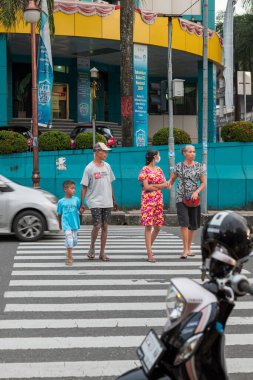 Ambon, Endonezya - 1 Haziran 2024: İnsanlar otoyolu geçiyor