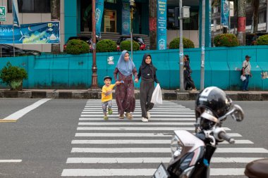 Ambon, Endonezya - 1 Haziran 2024: İnsanlar otoyolu geçiyor