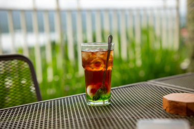 Dışarıdaki masada bir bardak taze içecek.