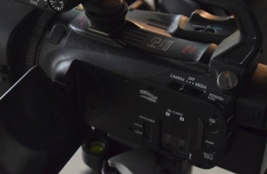 Black camcorder in a studio with a microphone.