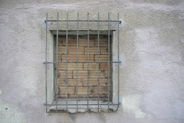 Terk edilmiş bir evin tahta kaplı penceresinin arka planı.