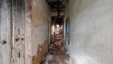 Bir köyde terk edilmiş ve harap olmuş bir evin koridoru.