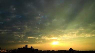 Şafak vakti şehrin üzerinde dönen İsa ışığı. Altın ışık ve rüya gibi bulutlar, manzaralı gökyüzü manzarası. atmosferin crepuscular ışını garip bir parıltı videosu oluşturur. Chiayi Şehri, Taiwan4K Düşük açı, geniş açı lens.