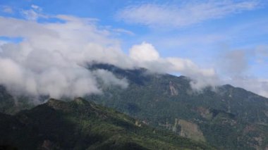 The astonishing cloudscape in front of your eyes. The surging, churning sea of clouds on the top of the green mountain and blue sky form a scenic scenery  view. Pingtung ,Taiwan. 4K. Eye level shot