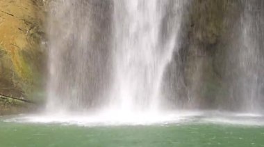 Şelalenin alt kısmındaki derin havuzun dalgalarının yakın plan görüntüsü. Akan sular, güçlü bir etki oluşturur. Tayvan 'ın Chiayi ilçesi Dabu' da düşük açı fotoğrafçılığı. 4K Gerçek zamanlı