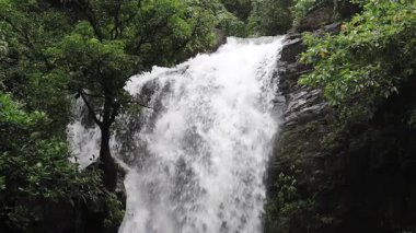 Şelalenin üst su çıkışındaki dalgalara yakın çekim. Akan su, güçlü etki, manzaralı bir sahne oluşturur. Yüksek açı. Laiyi, Pingtung Bölgesi, Tayvan. Düşük hareket. 4K.