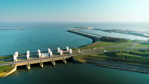 エンクロージャーダム アシュヴァルディク ダムの長い道を走る車 遠くの大型貨物船 フリースランド オランダ 4Kドローンフッテージ — ストック動画