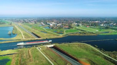 Bir su kemerini geçen iç kargo gemisi - Friesland, Hollanda 4K İHA görüntüsü