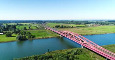 IJssel Nehri üzerinden Hanzeboog Köprüsü 'nü geçen bir trenin takibi - Zwolle, Hollanda, 4K İHA görüntüsü