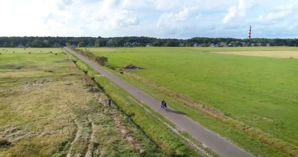Young Couple Riding Tandem Bike Lighthouse Background Ameland Nizozemsko Drone — Stock video