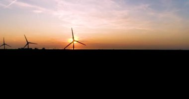 Güzel Günbatımında Rüzgar Türbinlerinin Silüetleri, Bıçaklar Gün Işığını Engelliyor, Yüksek Karşıtlık, Hareketli Sol - Friesland, Hollanda, 4K Drone Görüntüleri
