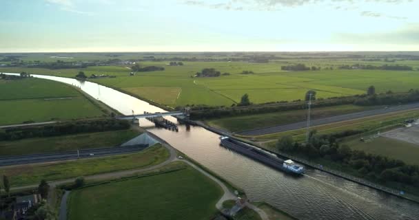 水道とハイウェイを横断する貨物船 グロウ フライスランド オランダ 4Kドローンフッテージ — ストック動画