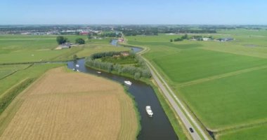 Hollanda Düzlüklerindeki Bendy River 'da Eğlence Tekneleri Sırası - Friesland, Hollanda, 4K Drone Görüntüleri