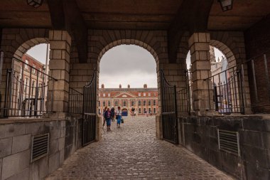 Turistler İrlanda 'daki Dublin Şatosu' na giden bir kemere doğru gidiyorlar.