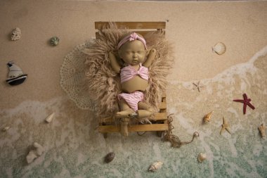 Kumsalda güneşlenen bir bebeğin fotoğrafı.