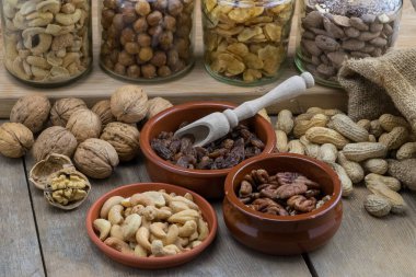 Cam kavanozlarda ve diğer kaplarda çeşitli kurutulmuş meyveler.