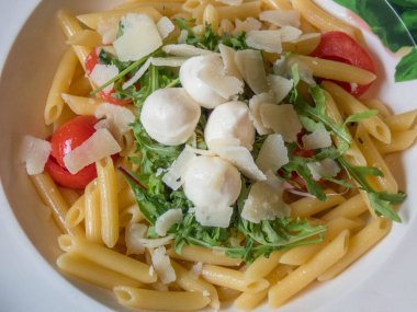 Bir tabak sebzeli makarna ve mozzarella.