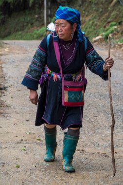 Sa Pa, Vietnam - 13 Nisan 2025: Muong Hoa Vadisi 'nde yürüyen yaşlı yerli kadın