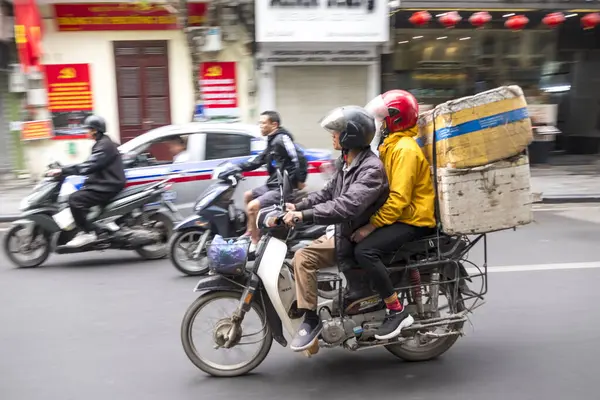 Hanoi, Vietnam - 11 Nisan 2025: Motosikletli insanlar sokaklarda dolaşıyorlar