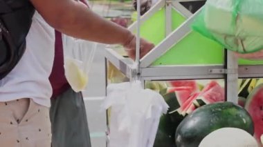 Rujak (meyve salatası) satıcının alıcıya servis etme süreci. Rujak tipik bir Endonezya yemeğidir..
