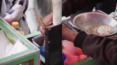 Telur Gulung 'un kızartma işlemi. Telur Gulung, çubukta kızartılmış yumurta ve pirinç eriştesinden yapılmış geleneksel Endonezya sokak yiyeceğidir..