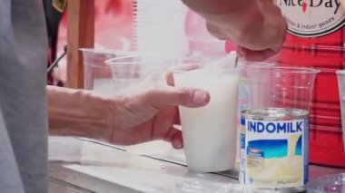 Es Kelapa Muda ya da genç hindistan cevizi buzu, popüler bir Endonezya içkisi. Satıcı alıcıya genç hindistan cevizi buzu servis ediyor..