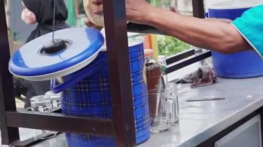 Es Kelapa Muda ya da genç hindistan cevizi buzu, popüler bir Endonezya içkisi. Satıcı alıcıya genç hindistan cevizi buzu servis ediyor..