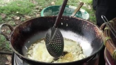 Soya fasulyesinden yapılmış Endonezya spesiyali Tempe Mendoan 'ı kızartan sokak yemekleri satıcısı..