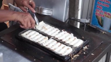 Geleneksel pazarlarda tüccarların çeşitlilik (gandos) pastaları yapma süreci. Endonezya sokak yemekleri.