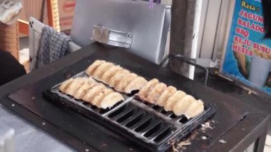 Geleneksel pazarlarda tüccarların çeşitlilik (gandos) pastaları yapma süreci. Endonezya sokak yemekleri.